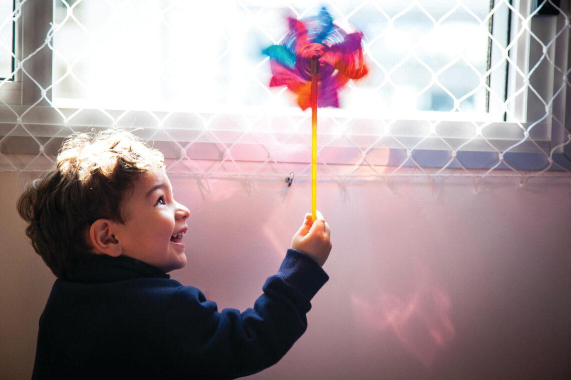 a boy playing with a pinwheel
